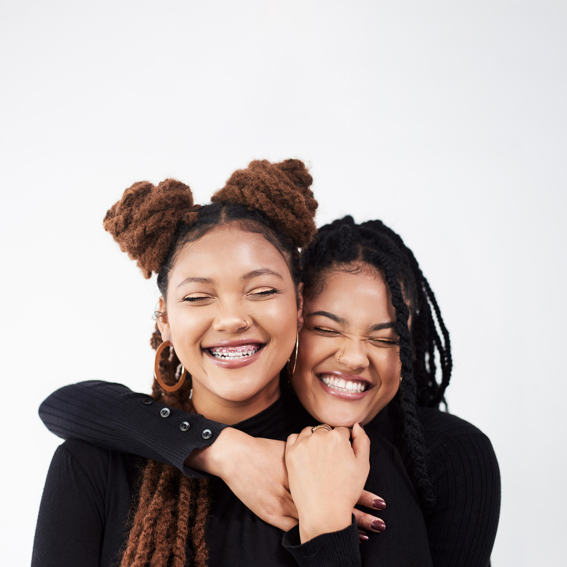 two smiling women, one wearing braces