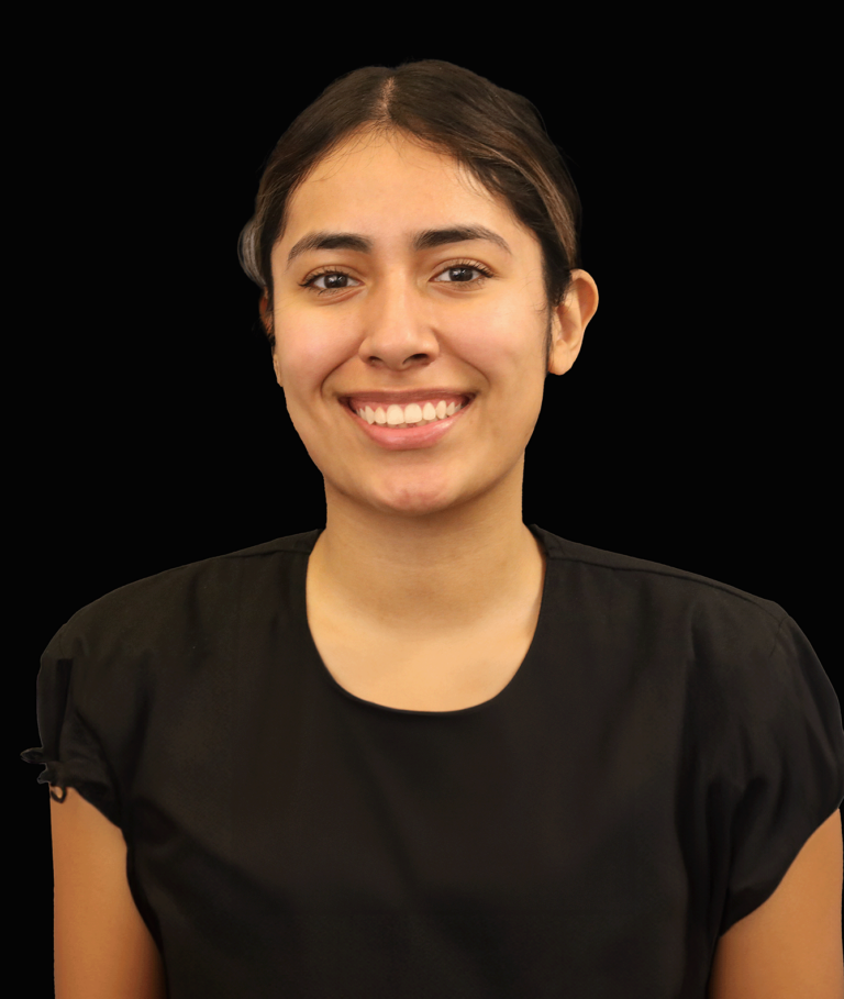 Michelle, a woman with brown hair pulled back and a black shirt, stands against a black background.