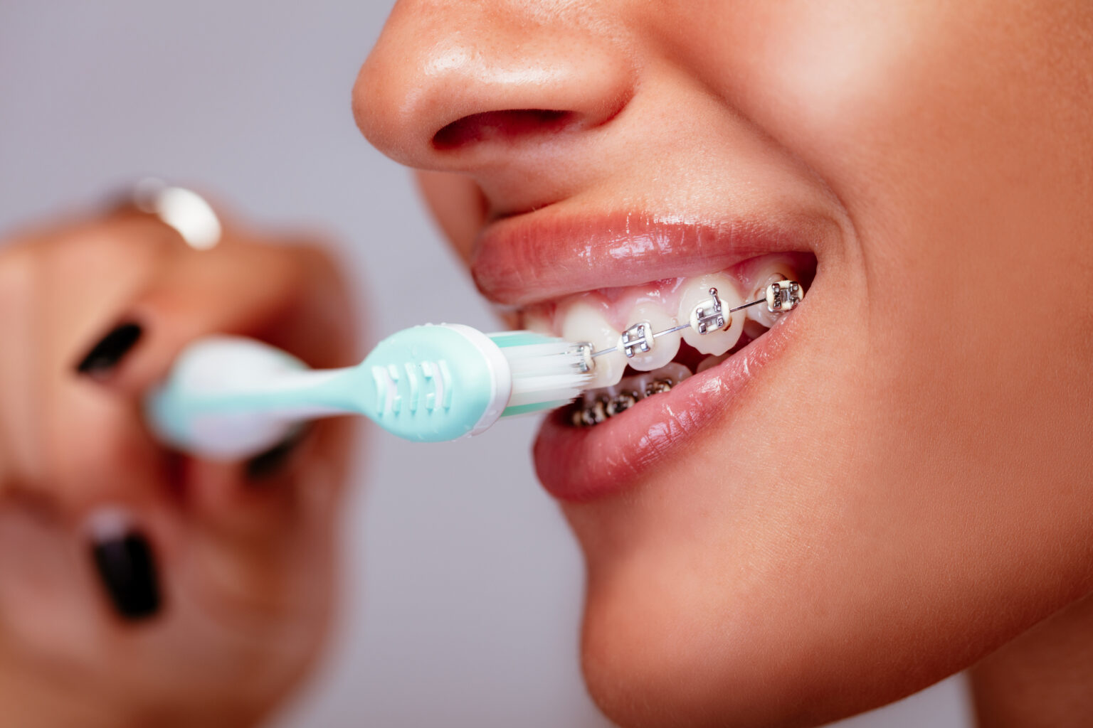 woman brushing her braces and teeth
