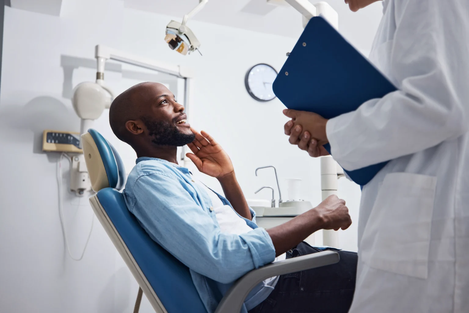 Man consulting with his orthodontist while sitting in the orthodontic treatment chair